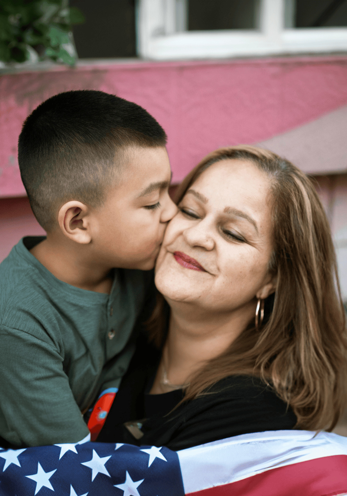 Familia latina sonriente sostiene la bandera de Estados Unidos